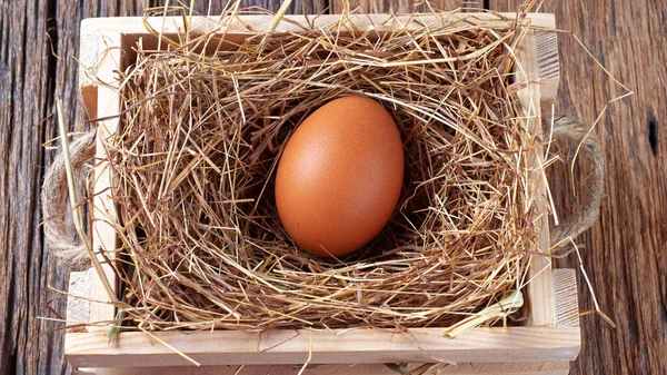 fresh eggs on wooden box with straw on wooden texture background in the night