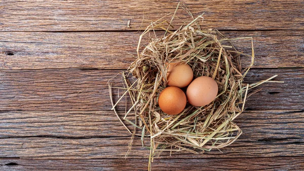 fresh eggs on wooden box with straw on wooden texture background in the night