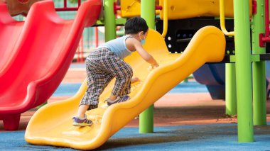 Dışarıda oyun oynayan Asyalı bir çocuk yeni bir şeyle heyecanlanıyor, açık hava aktivitesiyle öğreniyor, çocuk gelecekte büyümek için büyük bir dünyaya gidecek.