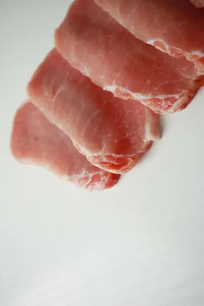  Beyaz arka planda baharatlı dilimlenmiş çiğ et.