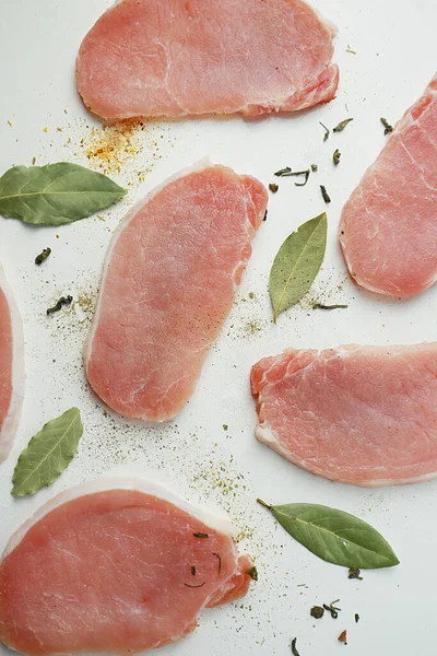  Beyaz arka planda baharatlı dilimlenmiş çiğ et.