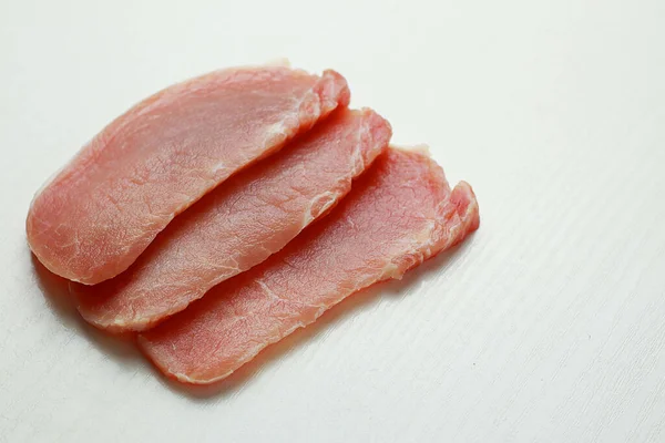  Beyaz arka planda baharatlı dilimlenmiş çiğ et.