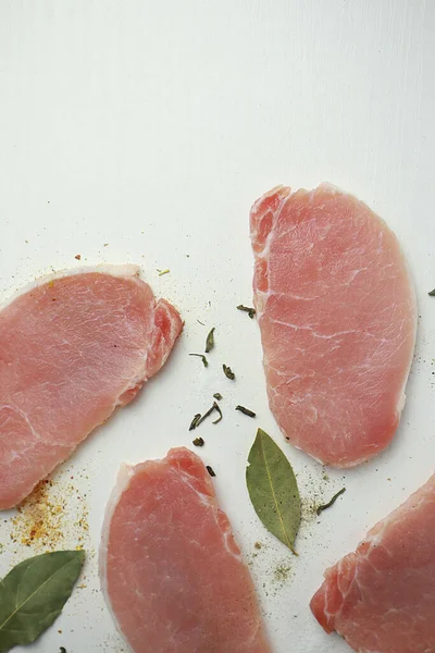  Beyaz arka planda baharatlı dilimlenmiş çiğ et.