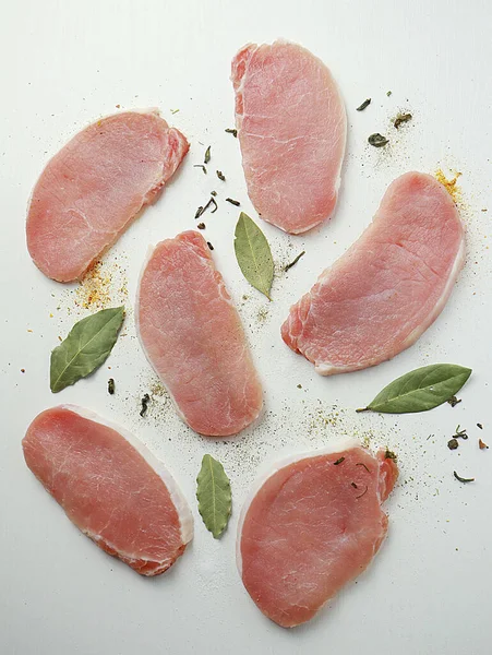  Beyaz arka planda baharatlı dilimlenmiş çiğ et.