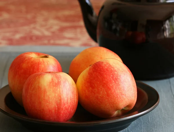 Четыре яблока на тарелке — стоковое фото