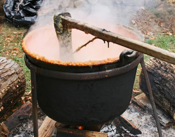 Cozinhar manteiga de maçã em um caldeirão de ferro fundido — Fotografia de Stock
