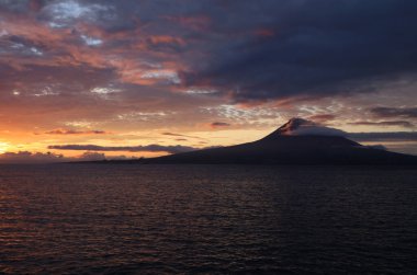 Şafak ışıkları Pico adasını ve yanardağı Azores 'i aydınlatır.