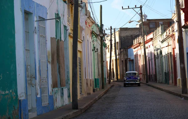 Οδός με πολύχρωμα σπίτια και ένα παλιό αυτοκίνητο στη μέση, Camaguey, Κούβα — Φωτογραφία Αρχείου
