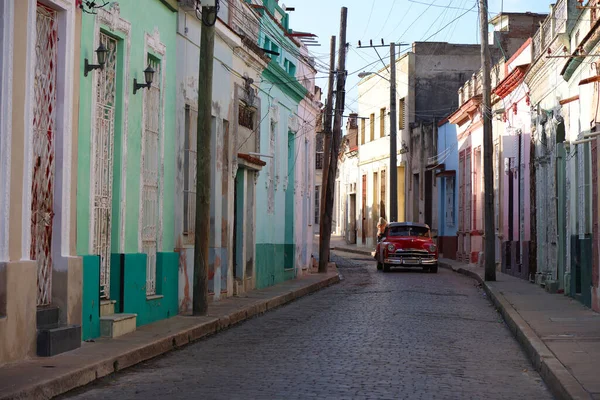 Οδός με πολύχρωμα σπίτια και ένα παλιό αυτοκίνητο στη μέση, Camaguey, Κούβα — Φωτογραφία Αρχείου