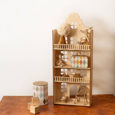 Çok renkli pencereli ahşap bir ev. Doğal ahşaptan yapılmış. Oyuncak evi.