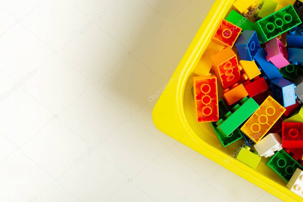 Many toy blocks in different colors making up one large square shape in top view. Toys and games. Leisure and recreation.