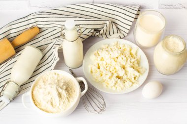 Mutfak malzemeleri üst görünüm. Süt ürünleri, un, tereyağı, şeker, krep, kek, kek veya turta için hamur hazırlamak için süt. Uzayı kopyala Düz plan. Beyaz tablo arkaplanı.