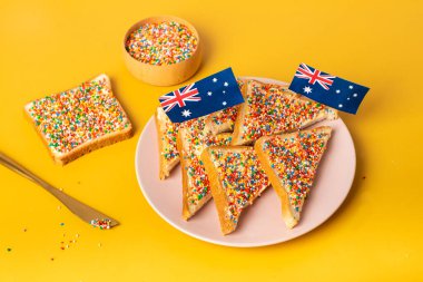 Tereyağı bıçaklı peri ekmeği, yan görüş. Sarı arka planda ünlü geleneksel Avustralya yemeği Peri Ekmeği.