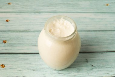 Mavi arka planda bir kavanozda tatlı krema. süt ürünleri.