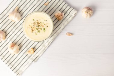 Beyaz bir masada sarımsak sosu. Evrensel sarımsak sosu.