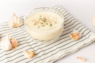 Beyaz bir masada sarımsak sosu. Evrensel sarımsak sosu.