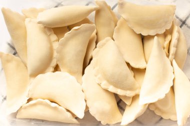 Beyaz bir masada plastik bir kabın içinde donmuş ev yapımı hamur tatlısı..