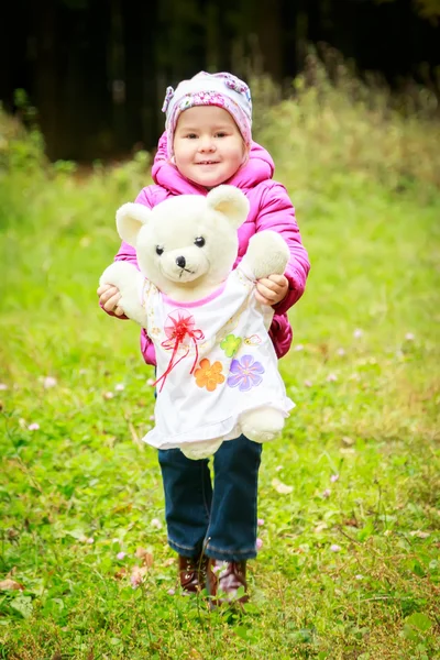 Маленькая девочка в лесу с медведем — стоковое фото