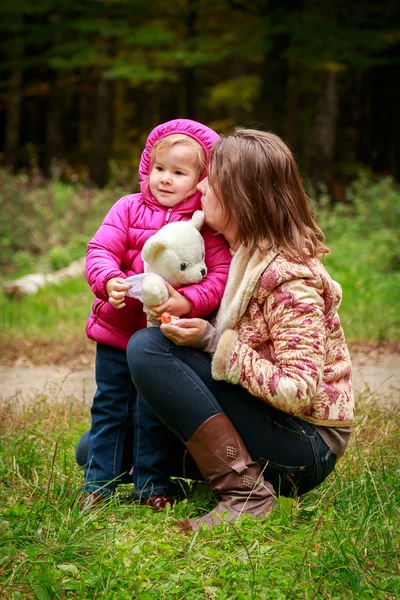 Mom and daughter in the autumn forest — Stock Photo, Image