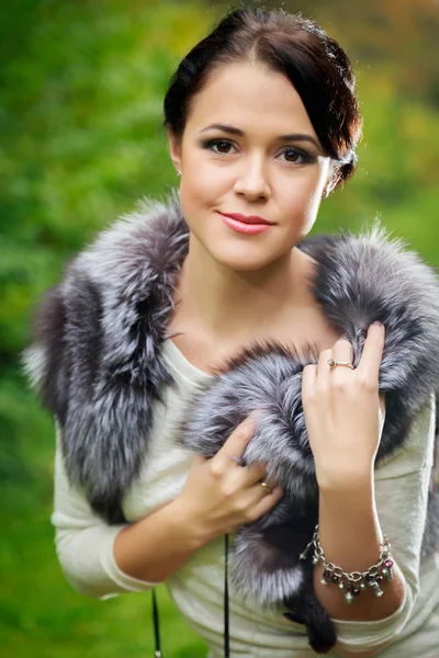 Belle fille dans une jupe rouge et un gilet de fourrure dans la forêt — Photo