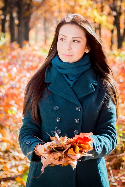 Fille exploitation feuilles dans le parc d'automne — Photo