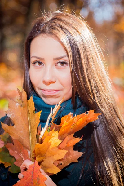 Dívka s hromadou listí v podzimním parku — Stock fotografie