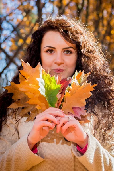 Fille avec bouquet de feuilles dans le parc d'automne — Photo