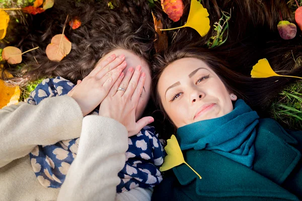 Chicas tumbadas en la hierba en el parque de otoño — Foto de Stock