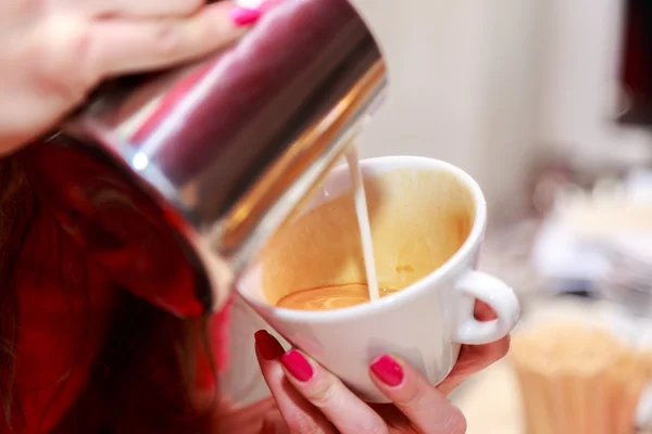 Female hands making cappuccino — Stock Photo, Image