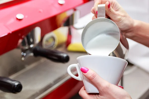 Female hands pouring milk in cup — Stock Photo, Image