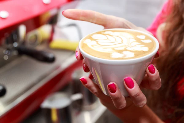 Female hands holding cappuccino cup — Stock Photo, Image