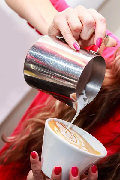 Vrouwelijke handen maken cappucino — Stockfoto