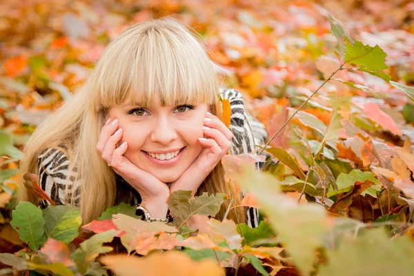 Jonge vrouw in bladeren — Stockfoto