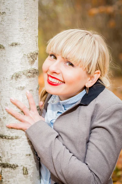 Söt blond kramar träd — Stockfoto