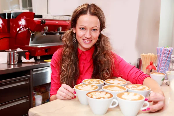 Mujer con siete tazas de capuchino —  Fotos de Stock