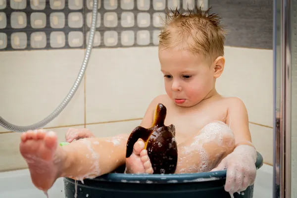 Le petit garçon est baigné dans la baignoire — Photo