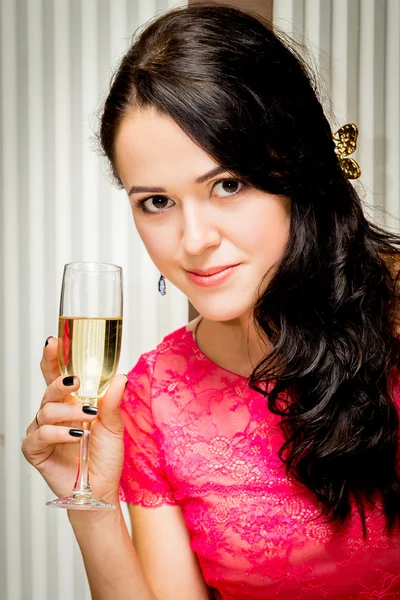 Девушка в розовом платье пьет шампанское — стоковое фото