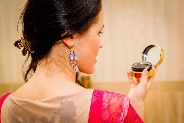 Woman looking at herself in mirror — Stock Photo, Image