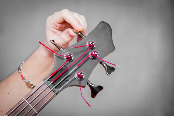 Особа, яка налаштовує гітару зі свого наконечника — стокове фото