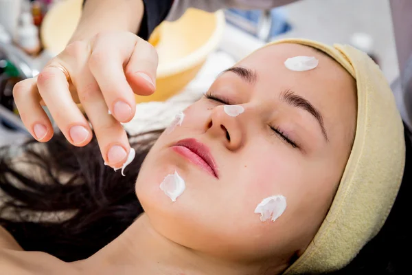 Cosmetólogo haciendo mascarilla facial a cara de mujer — Foto de Stock