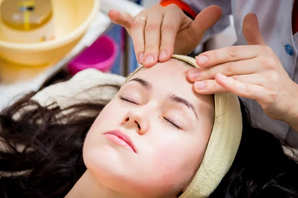 Le mani di cosmetologo applicano la crema a faccia di donna . — Foto Stock