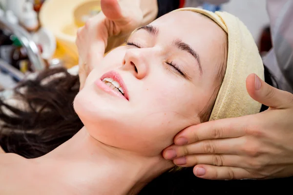 Ręce kosmetyczki stosuje krem na twarz kobiety. — Zdjęcie stockowe