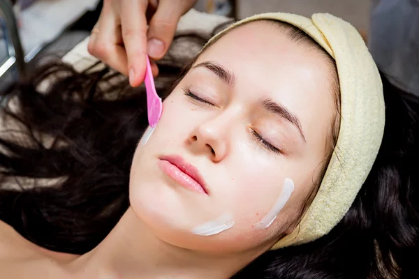 Cosmetólogo haciendo mascarilla facial a cara de mujer — Foto de Stock