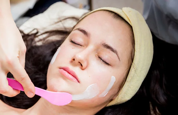 Cosmetólogo haciendo mascarilla facial a cara de mujer —  Fotos de Stock