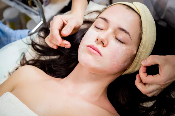 Cosmetólogo haciendo mascarilla facial a cara de mujer — Foto de Stock