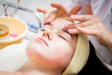 Makyöz, genç bir kadının profesyonel makyajını yapıyor.