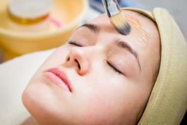 Makyöz, genç bir kadının profesyonel makyajını yapıyor.