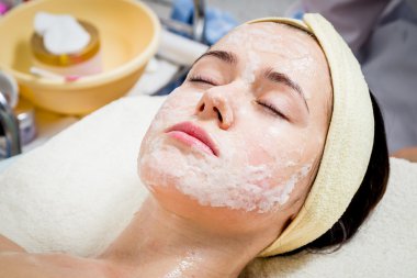 Makyöz, genç bir kadının profesyonel makyajını yapıyor.