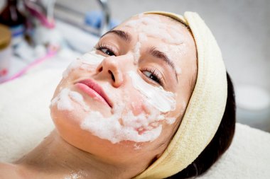 Makyöz, genç bir kadının profesyonel makyajını yapıyor.