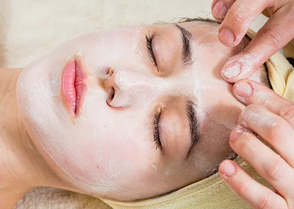 Cosmetologist aplicam a nata à cara da mulher — Fotografia de Stock